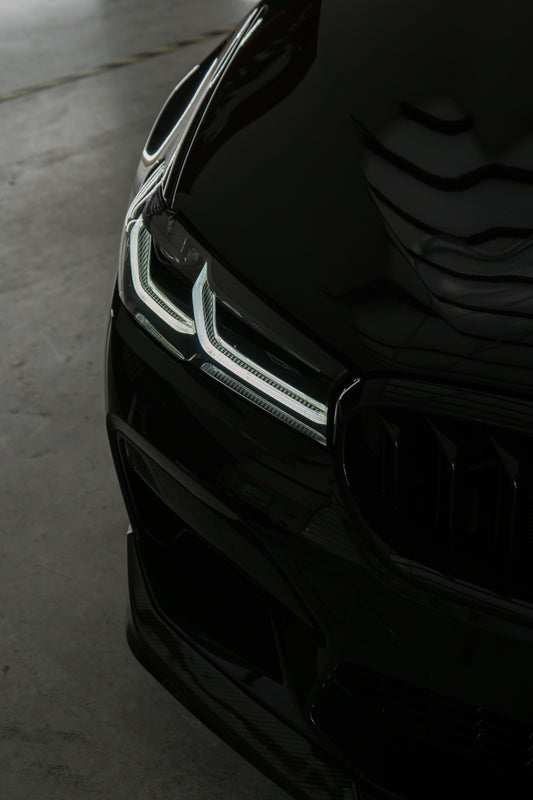 A car coated with ceramic, shining under sunlight, showcasing its glossy, smooth finish and superior protection from the elements.